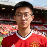 一位戴眼镜的中国年轻男性球迷头像，身穿红色曼联球衣，背景为球场看台